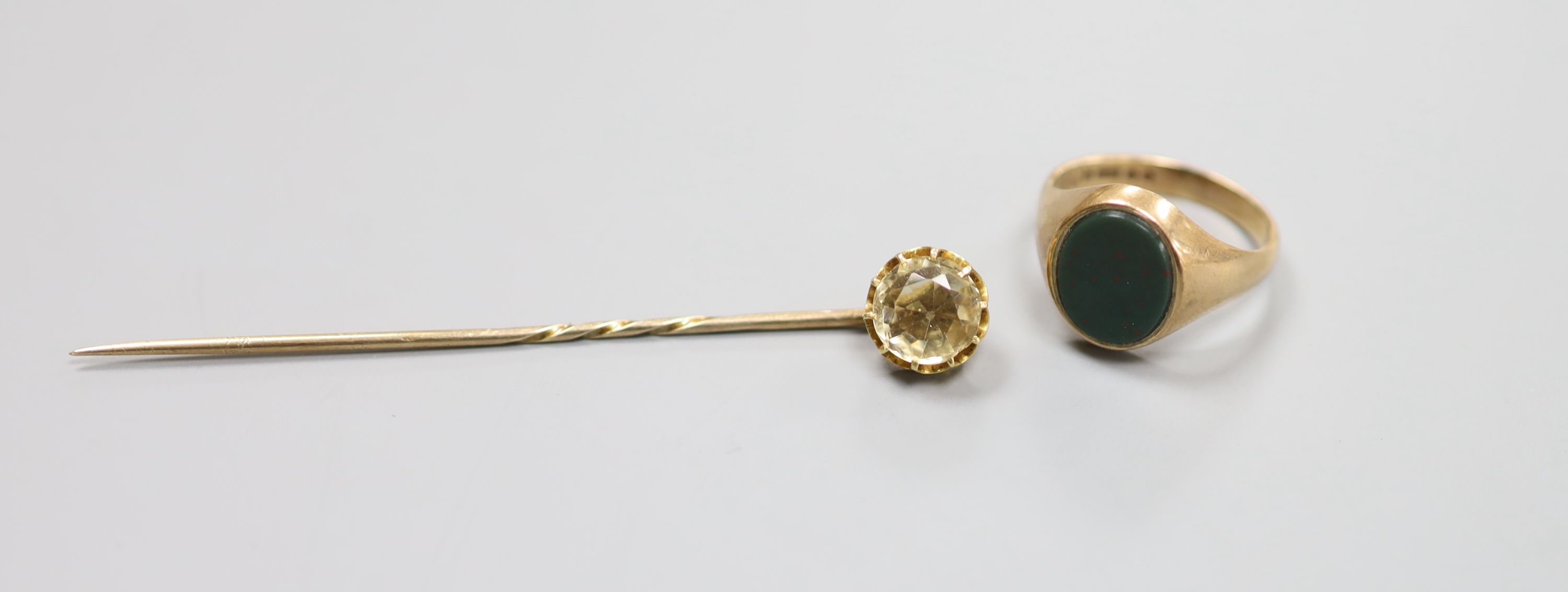 A modern 9ct gold and oval bloodstone set signet ring and an early yellow metal and citrine set stick pin